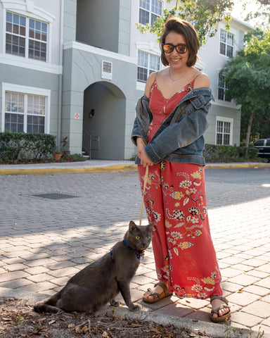Fuse Lenses employee Alanna outside in front of a building on a stone path with cat Oni