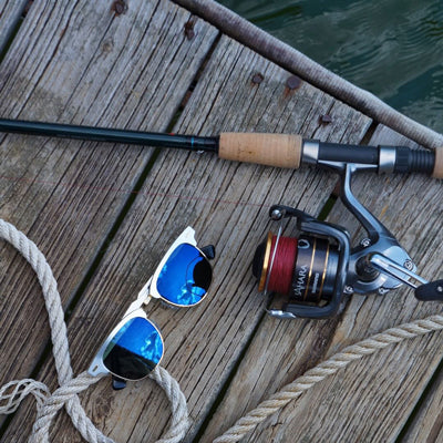 fishing pole and blue polarized sunglasses on a fishing dock