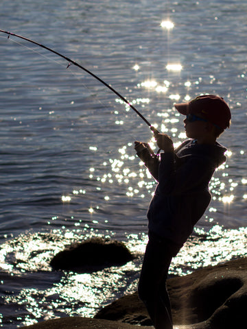 Young boy fishing along side the beach on Father's Day. Photo taken by Holger Link on Unsplash