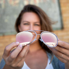 Women holding Ray-Ban Aviator Sunglasses in the lens color Rose Gold