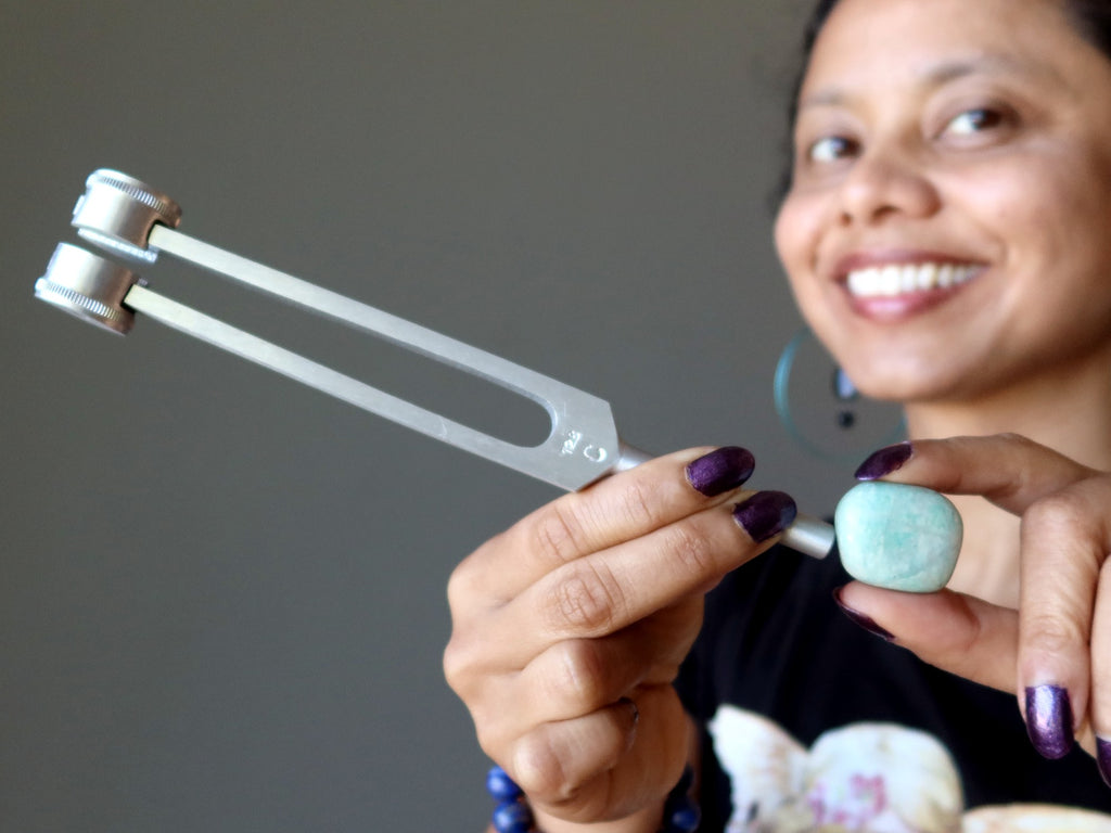 sheila of satin crystals using an amazonite stone and tuning fork at her throat chakra
