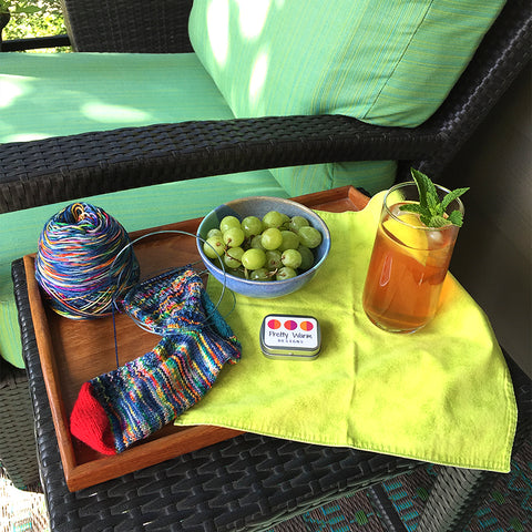 Iced tea, grapes, knitting socks on patio table with chair and plants by Pretty Warm Designs