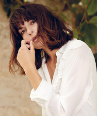 Woman in a white shirt looking at the camera