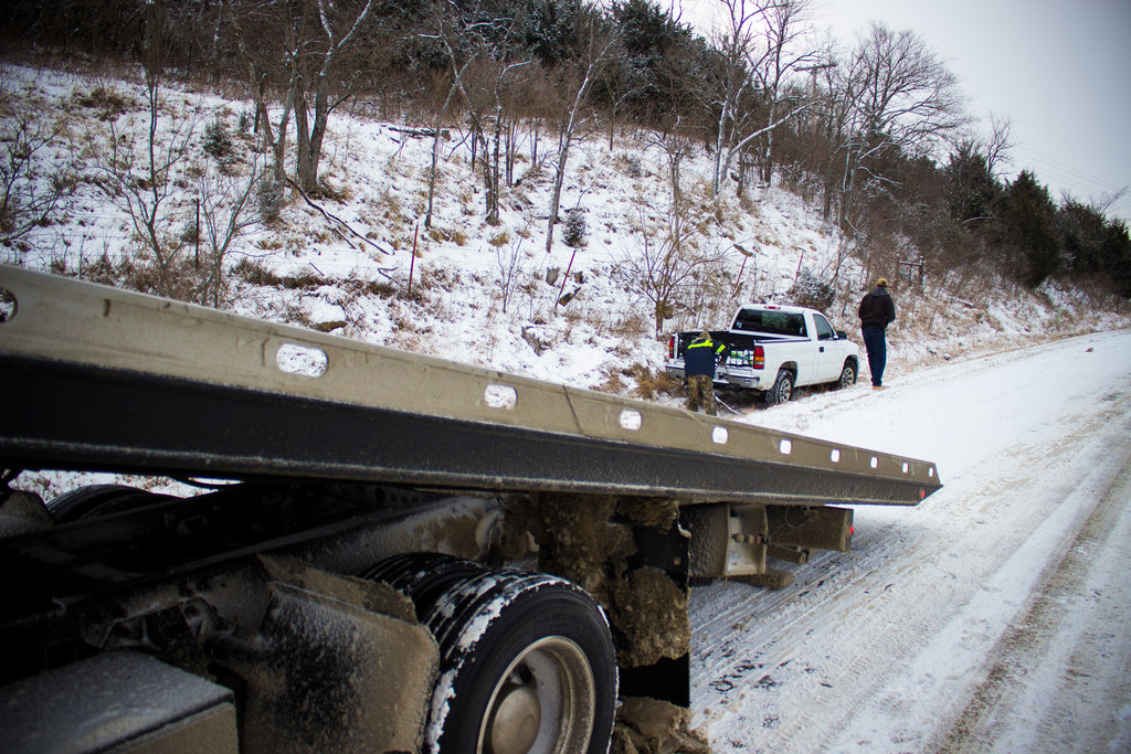 River City Recovery hooking up the winch line to pull the truck out of the ditch.