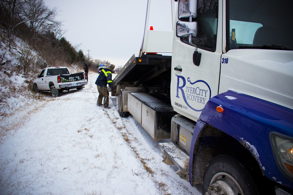 River City Recovery winching a truck out of the ditch on a snowy day in Lawrence, Kansas.