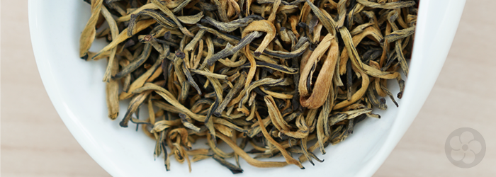 Gold Thread Reserve black tea leaves, dry, with bright golden color against a white tea dish