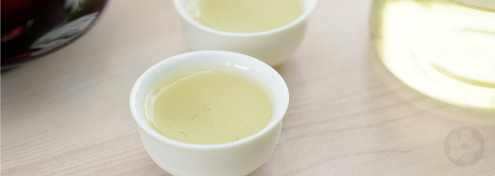 The bright, delicate color of Da Yu Lin oolong tea indicates natural sweetness in white tasting cups.