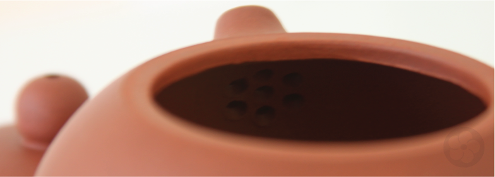 chinese teapots use strainer holes at the base of the spout instead of a basket inserted in the pot.