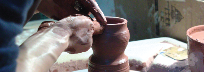 Xu De Jia throws pieces on the pottery wheel