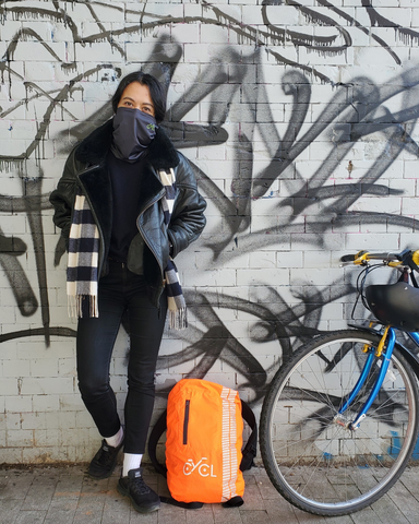 female wearing a pollution scarf next to a bicycle