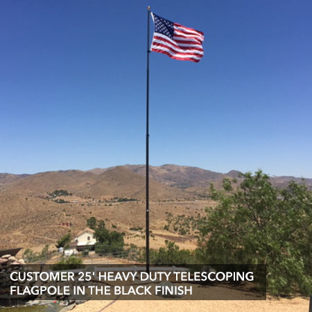 Customer flagpole with a black finish flying in his backyard