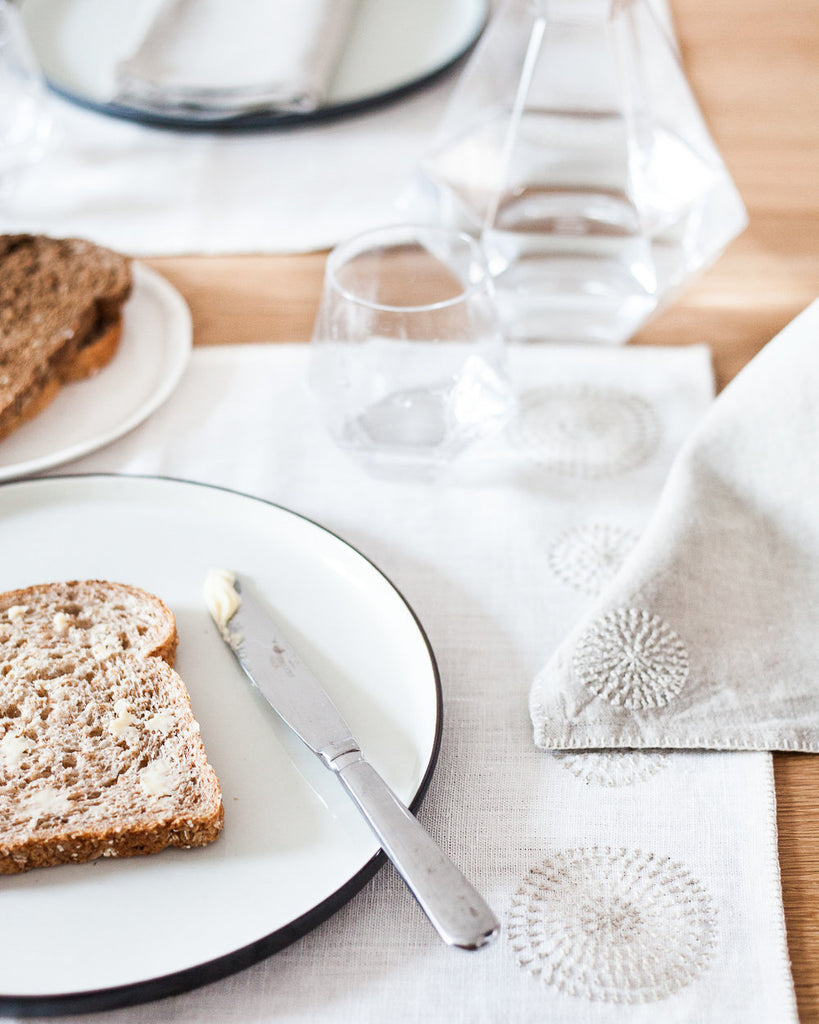 Breakfast table set with linen placemats and napkins from Artha Collections