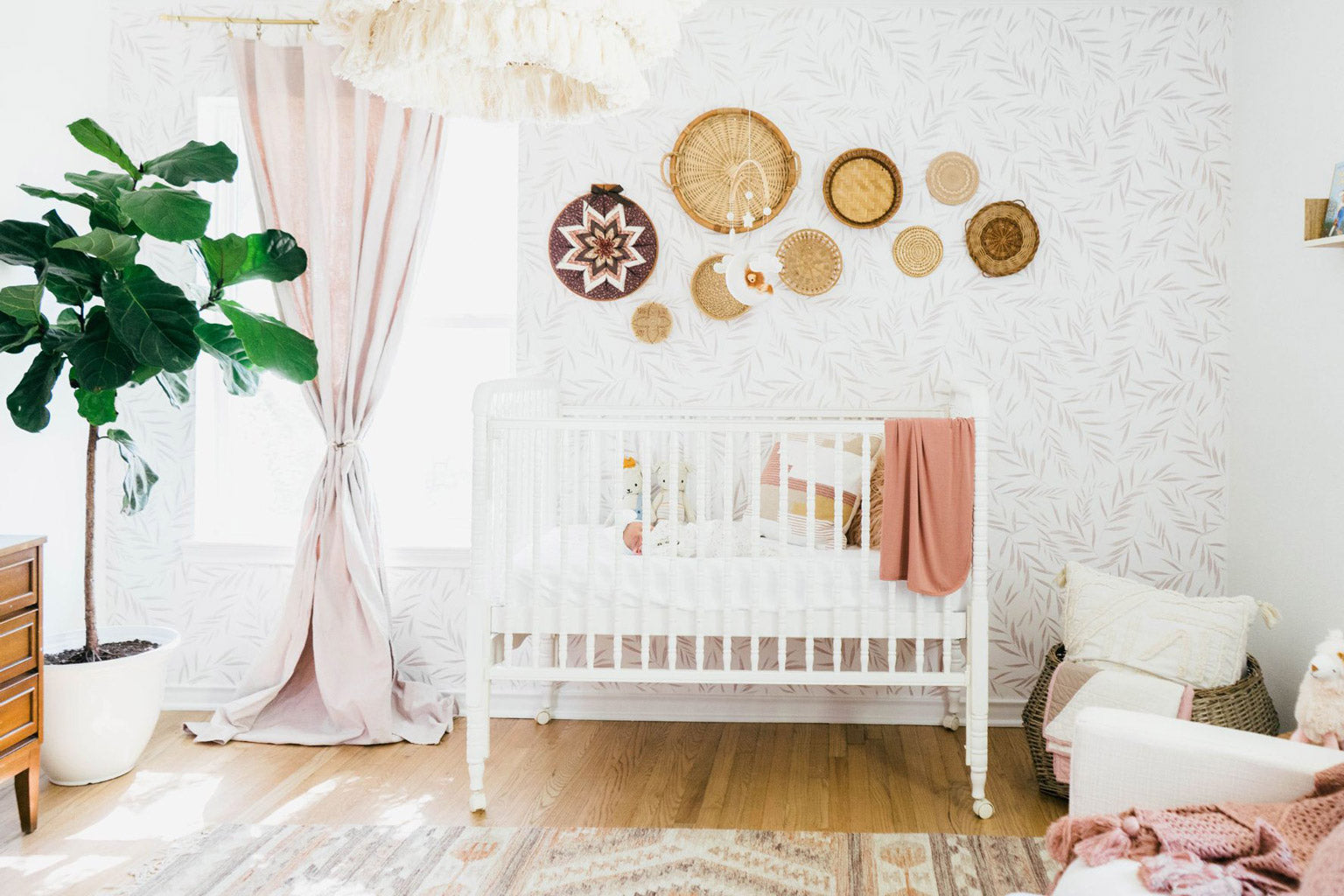 Farmhouse bohemian baby girl nursery with foliage wallpaper