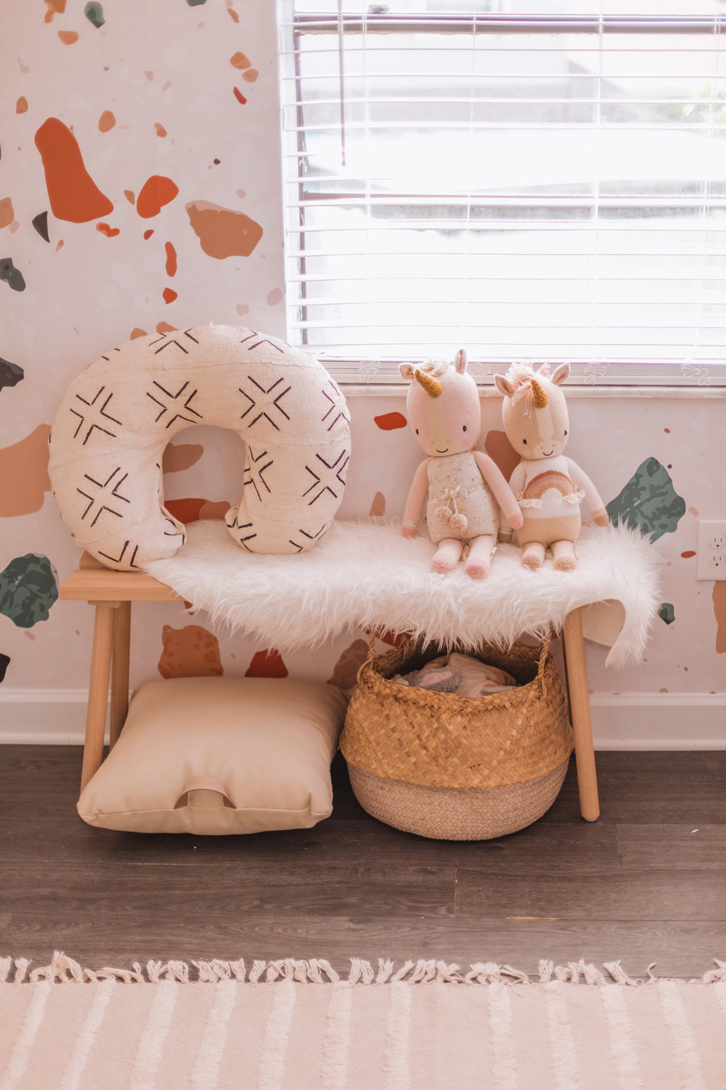 Gender neutral nursery interior with terrazzo design wall mural, light wood furniture and white interior decor elements