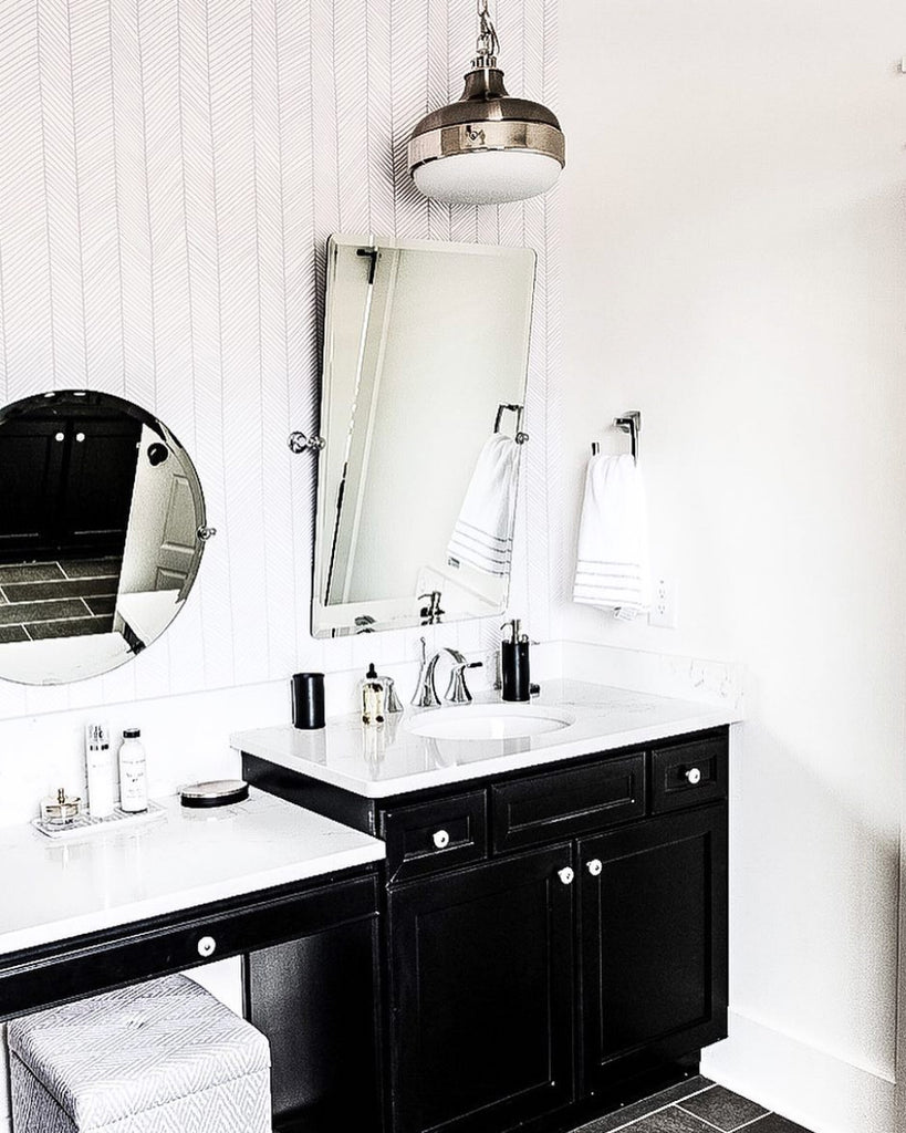 Chic bathroom interior with chrome fixtures, black vanity and removable wallpaper