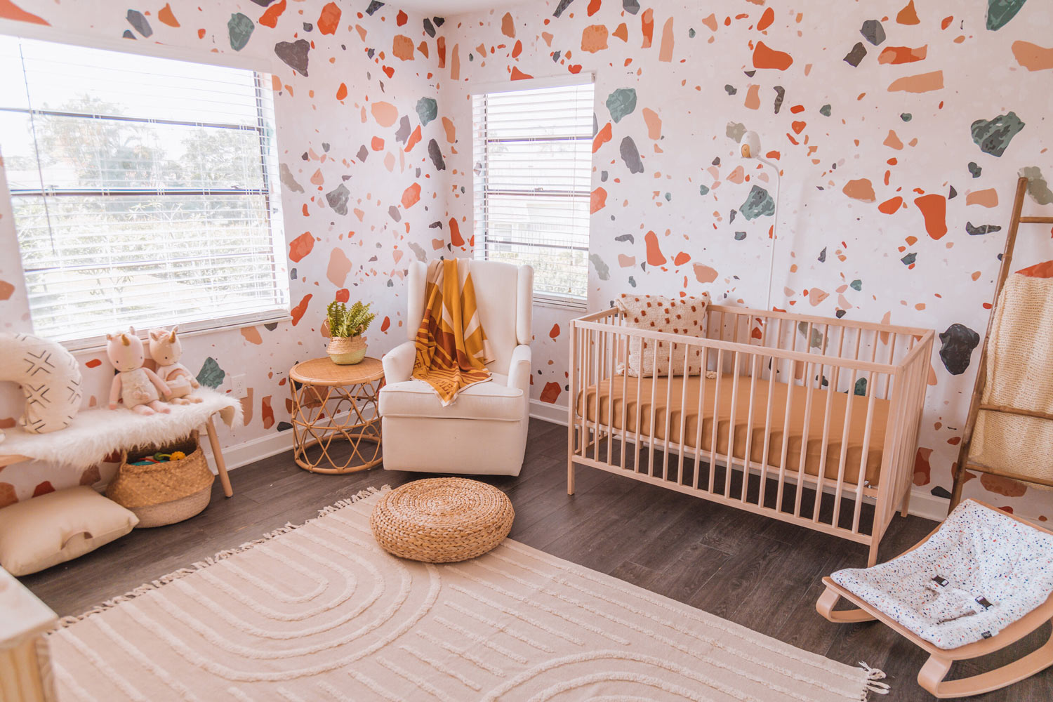 Warm tone baby girl nursery interior design with removable wallpaper feature wall