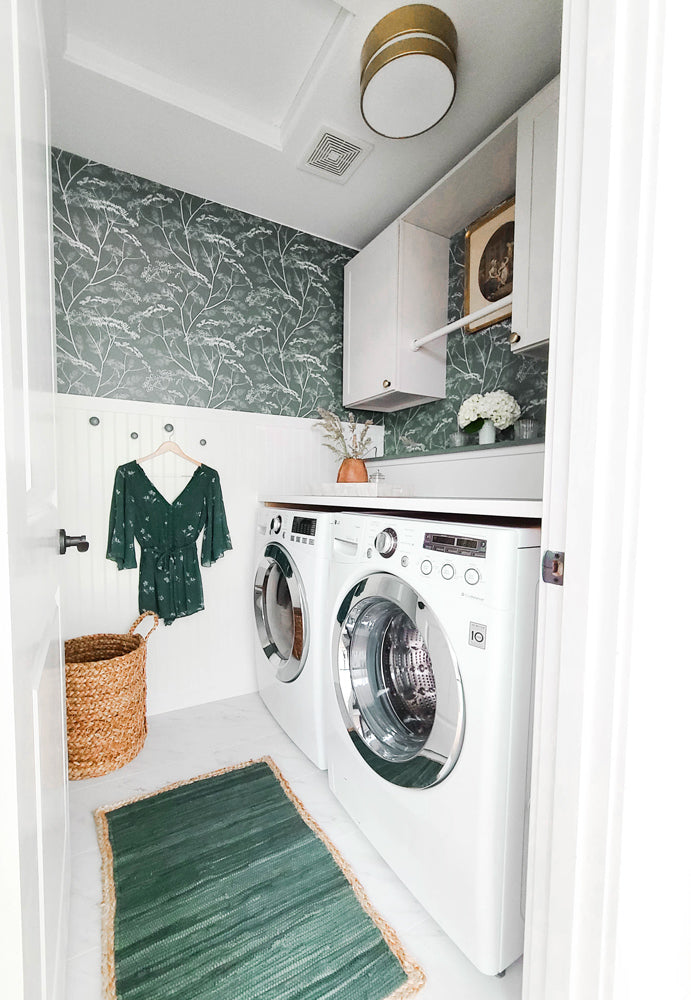 Stylish laundry room decorated with brass elements and green trendy removable wildflower wallpaper