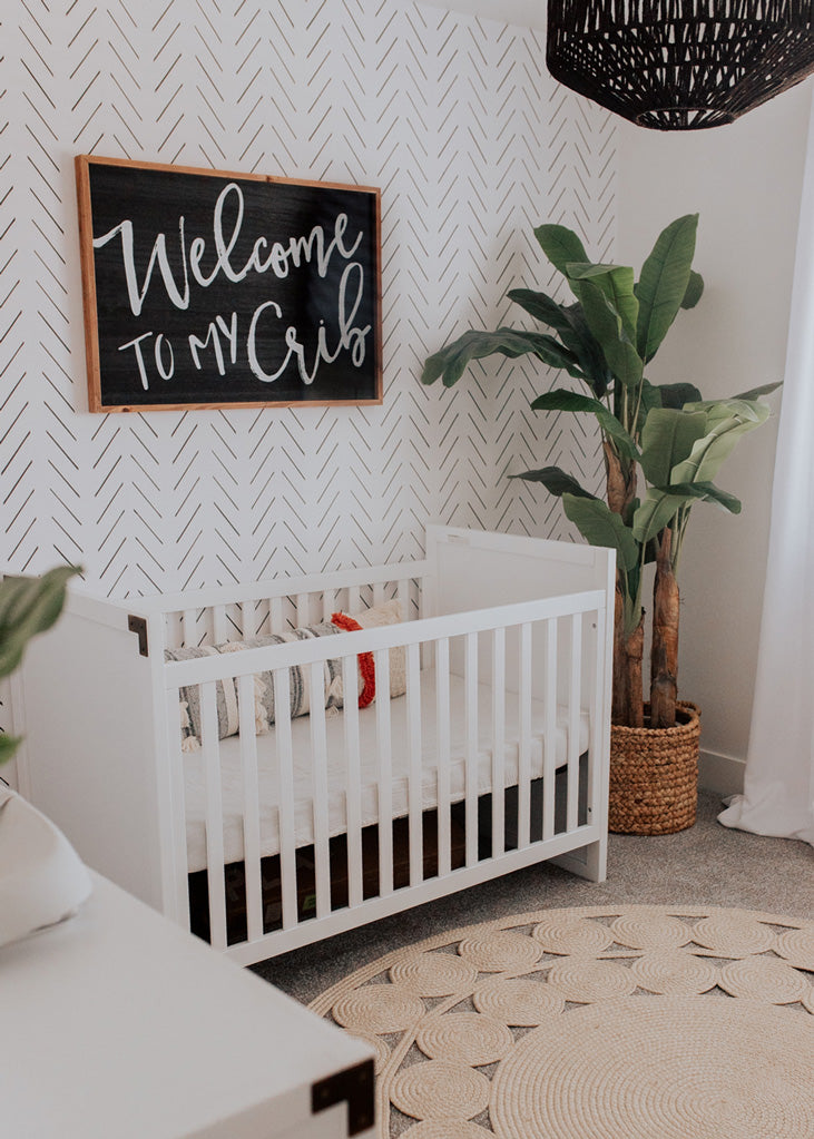 Witty baby boy nursery interior with herringbone wallpaper
