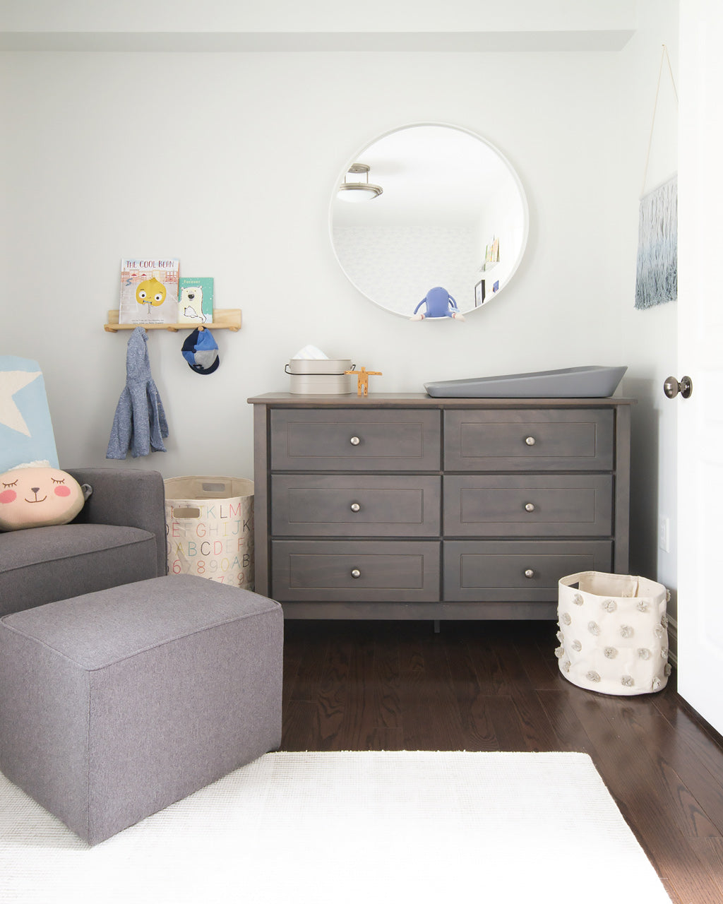 Nursery rocking chair and dresser in neutral grey color palette in white coastal theme nursery for baby boy