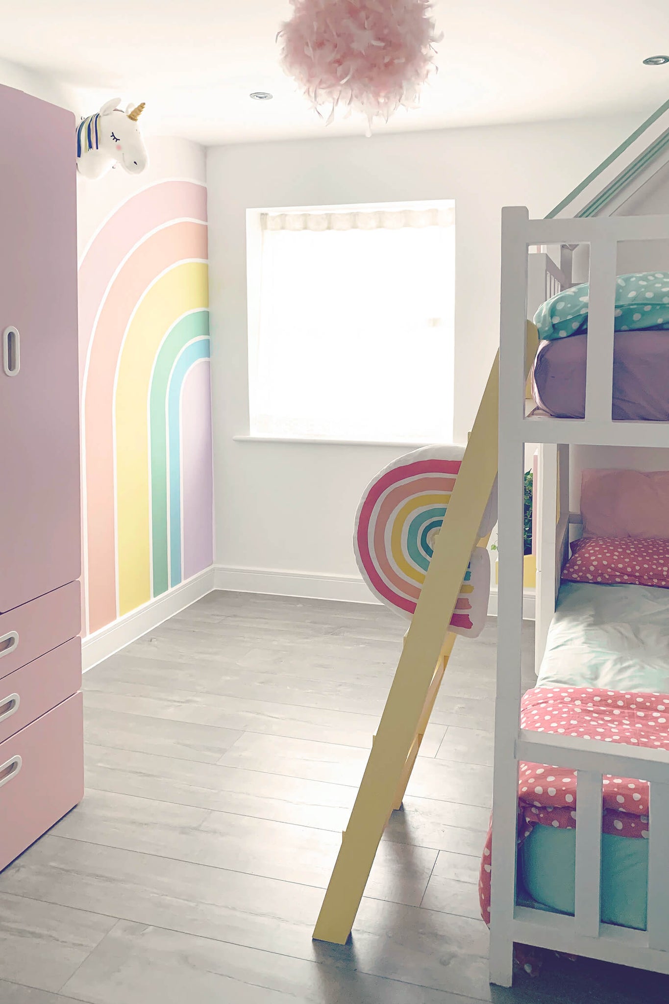 Soft pastel color rainbow unicorn themed girl's room interior with removable wallpaper