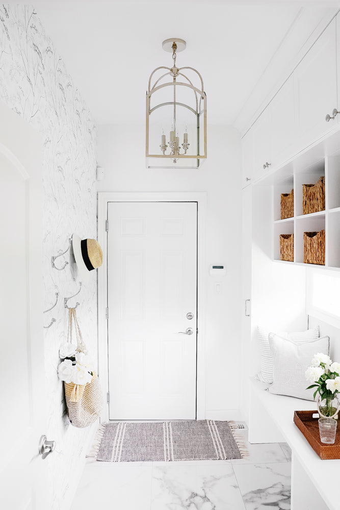 Modern white mudroom interior styled with wildflower removable wallpaper and natural woven interior pieces