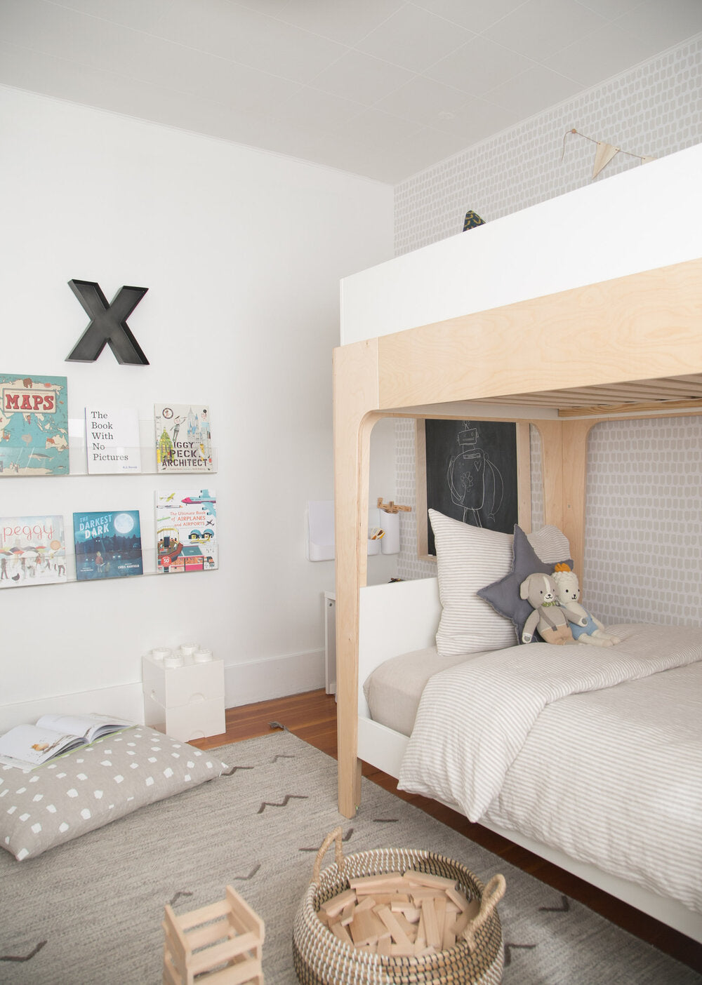 Boys room interior with floating book wall, wood bunk bed, light removable wallpaper and grey color area rug