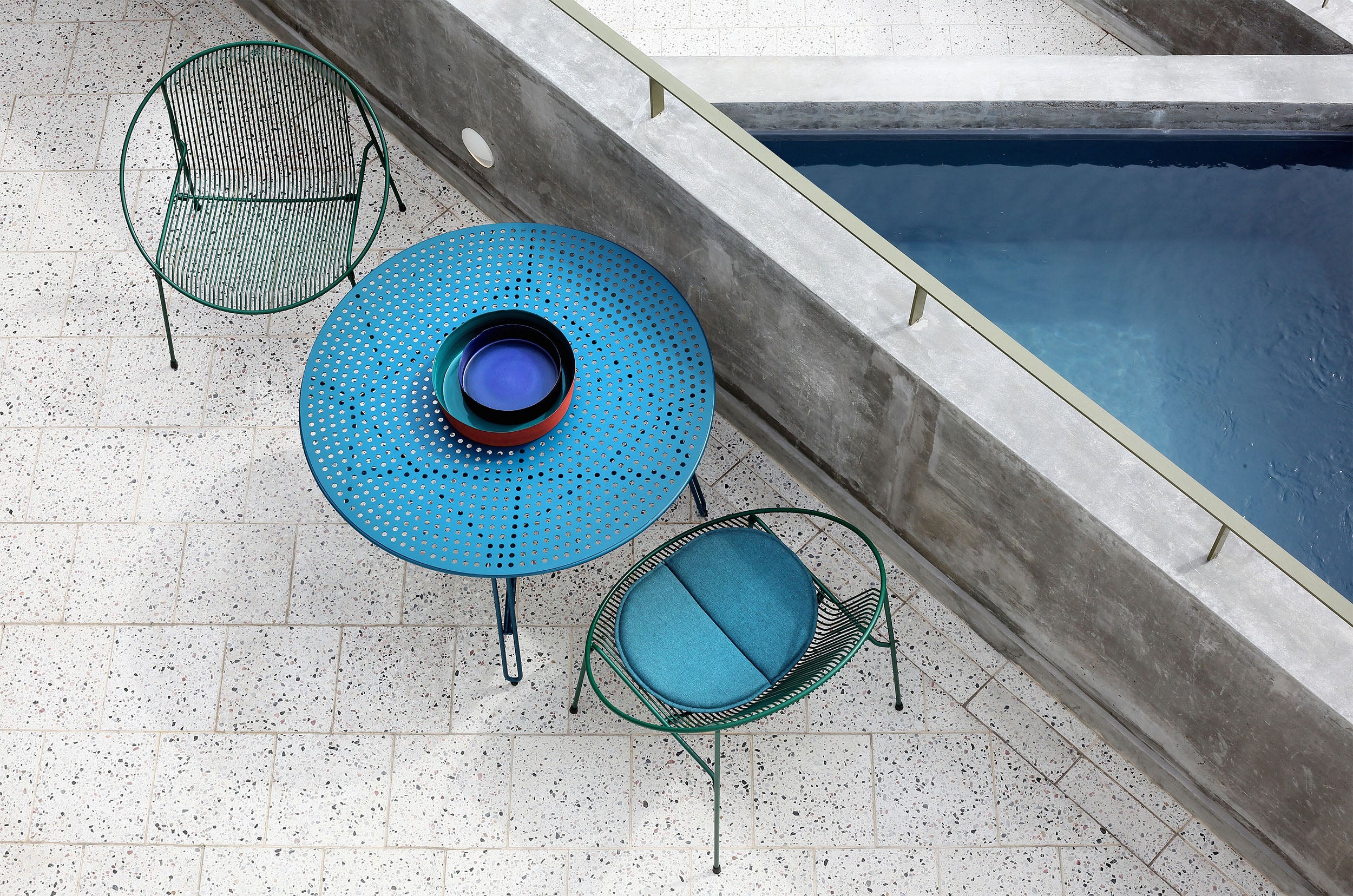 Haldane Martin, outdoor furniture, blue outdoor tables and chairs styled in an outdoor setting.  Haldane Martin outdoor furniture is available at Sarza home goods and furniture store in Rye New York. 