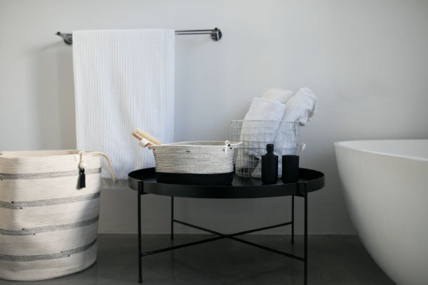 Mia Melange cotton baskets in black and white styled in a bathroom setting. Mia Melange products available at Sarza home goods and furniture store in Rye New York.