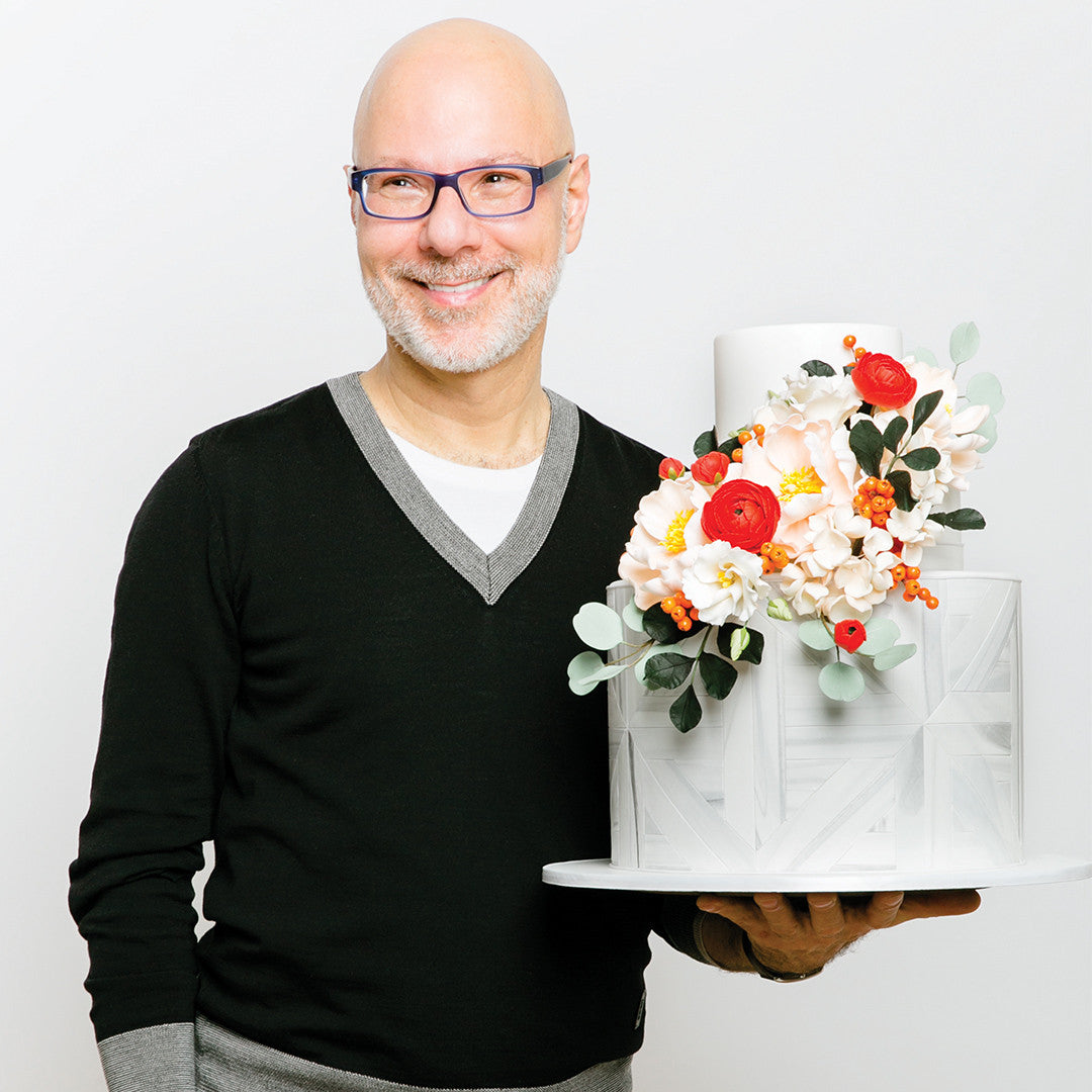 Wedding cake guru Ron Ben-Israel poses with his spiced wedding cake topped with magnificent sugar flowers!