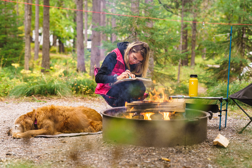 Dog sleeping on highlands pad next to campfire.
