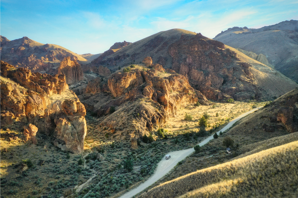 car on road through leslie gulch in eastern oregon.