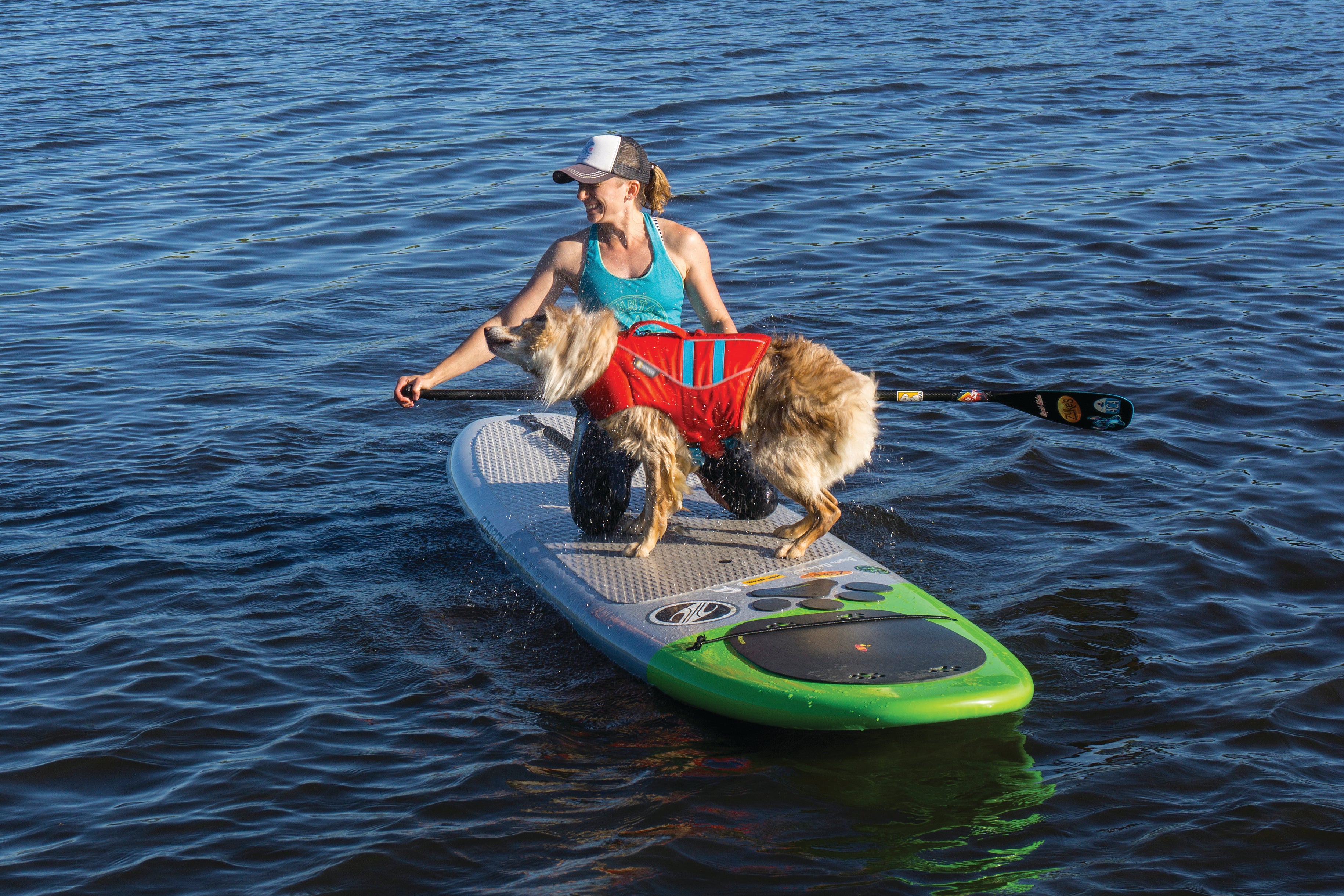 Maria helps bodie onto SUP using float coat handle for lift and assist.