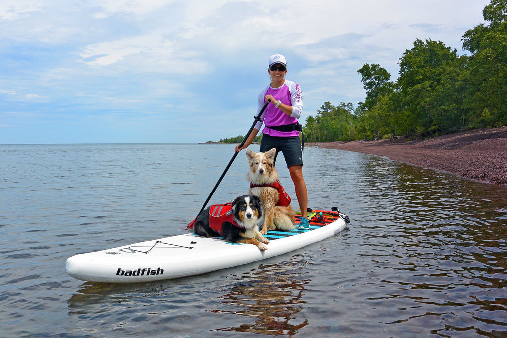 Maria, Riley and Kona paddling together along the red-pebbled beaches of Lake Superior.