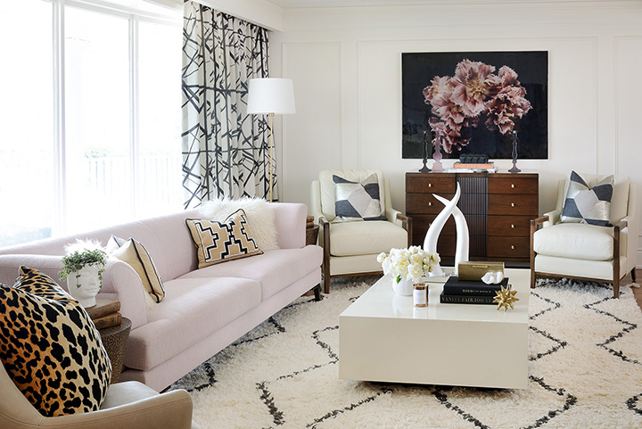 arianna-belle-pillows-in-living-room-designed-by-sarah-walker-photograph-by-Larry-Arnal-pink-sofa-channels-curtains-geometric-pillows-large-flower-art