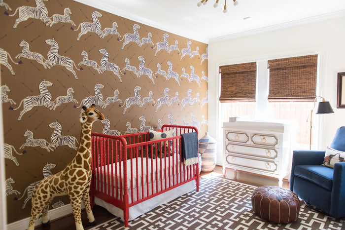 nursery with zebra wallpaper red crib and giraffe - interior designer Maddie Hughes