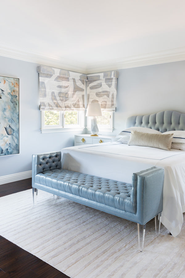 Designer Spotlight: Jenn Feldman | Blue bedroom with extra long decorative pillow tufted headboard bench at foot of bed and abstract art