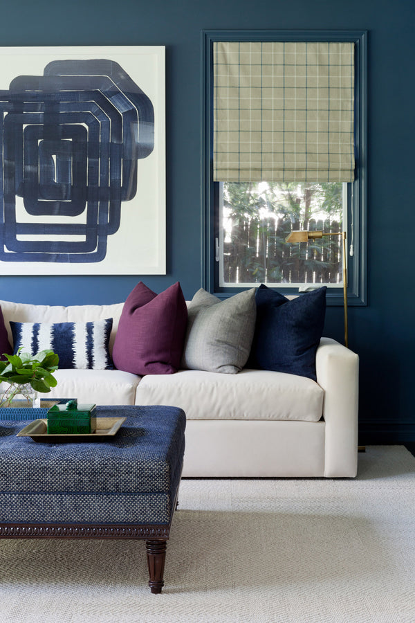 living room with dark navy walls abstract art and mix of designer pillows