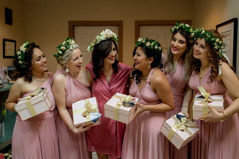 Henkaa A Bride's Story: Diana & Jas. Bride and bridesmaids exchanging bridesmaid gifts in pink silk bridal robes and flower crowns.