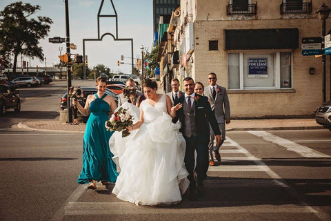 Jacqueline Sbeyti and Ayad Sbeyti lead the wedding party across the street during their wedding portraits.