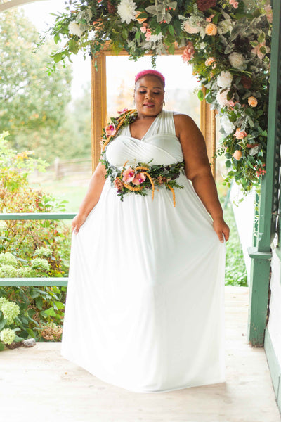  Henkaa Plus Sakura Chiffon Maxi Infinity Wedding Dress worn on Latoya Tayler in front of floral arch and gold frame.