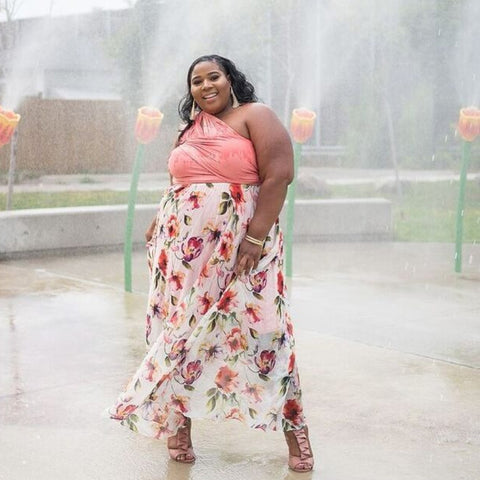 Women in coral infinity dress and patterned chiffon overlay at splash-pad park.