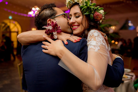Henkaa A Bride's Story: Diana & Jas. Multicultural bride and groom embrace in a hug. Bride in flower crown and corsage. 