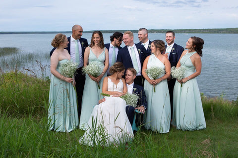 Ashley and Jordan pose with their wedding party at the lakes edge, bridesmaids are wearing Henkaa Sakura Maxi Convertible Dresses in Mint Green.
