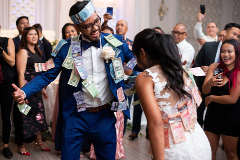 Remar and Kristina dance with money bills taped to their bodies during their Money Dance at their reception.