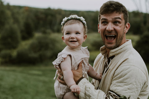 Alex Malnik husband in medieval outfit holding baby Mars Melnik during wedding. Featured on Henkaa A Brides Story: Lauren & Alex on the Henkaa infinity dress blog.