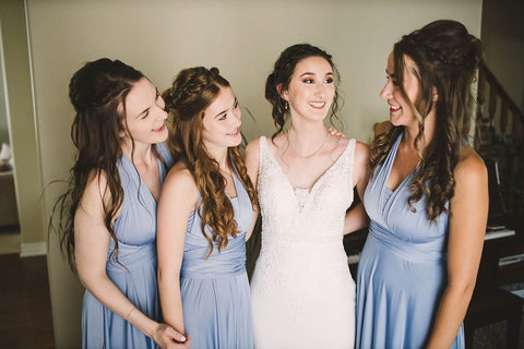 Rachel embraces her bridal party who are wearing Dusty Blue Henkaa Sakura Maxi Convertible Dresses.