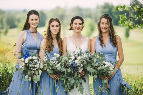 Rachel poses with her bridal party who are wearing Dusty Blue Henkaa Sakura Maxi Convertible Dresses.
