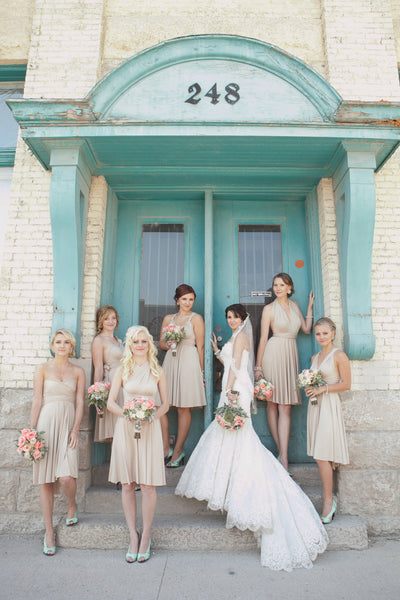 Bride and six bridesmaids wearing nude bridesmaid dresses at garden-themed wedding