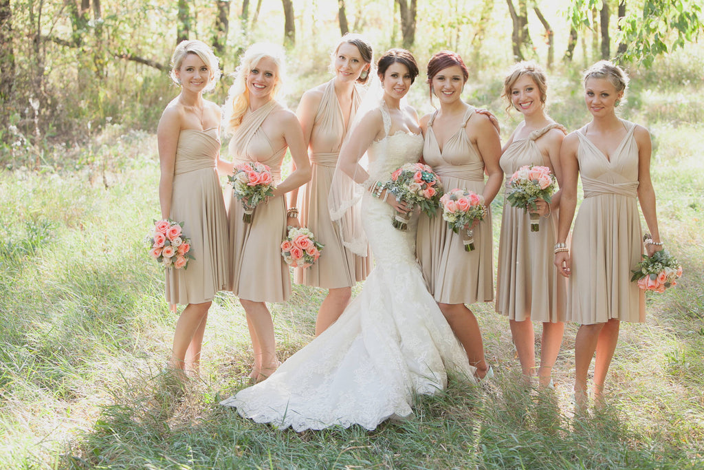 Bride and six bridesmaids wearing honey beige dresses outdoors