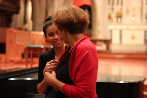 Joanna smiling while helping a performer out with her choir dress